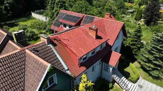 Dom z góry przed pracami, dach z paneli fotowoltaicznych i kominy – Słupsk, CleanTECH