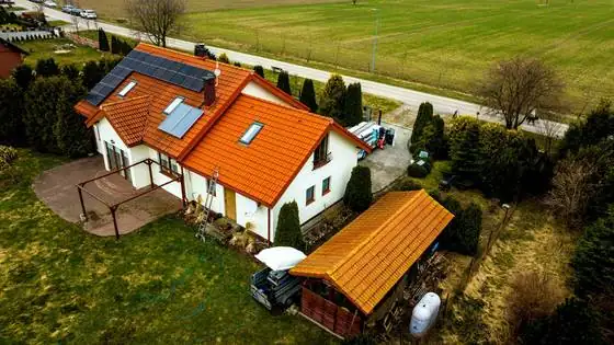 Dom z panelami fotowoltaicznymi i wiatą po myciu, widok od strony panelowej połaci – Bierkowo k. Słupska, CleanTECH