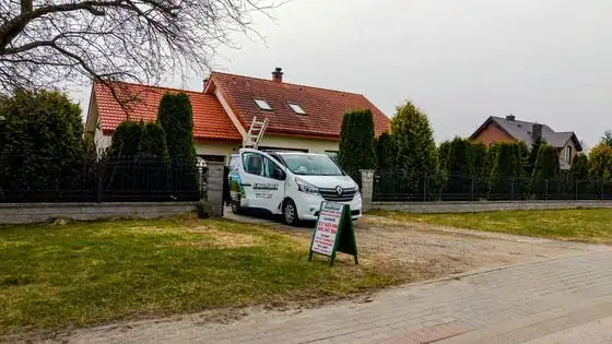 Samochód CleanTech z tablicą z ofertą mycia dachów i elewacji przed domem w Bierkowie